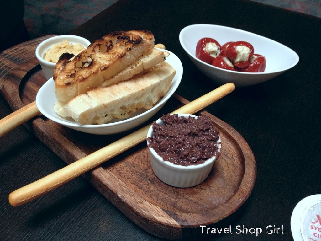 Crisp bread and Grissini sticks with hummus and olive tapenade, marinated peppers stuffed with feta